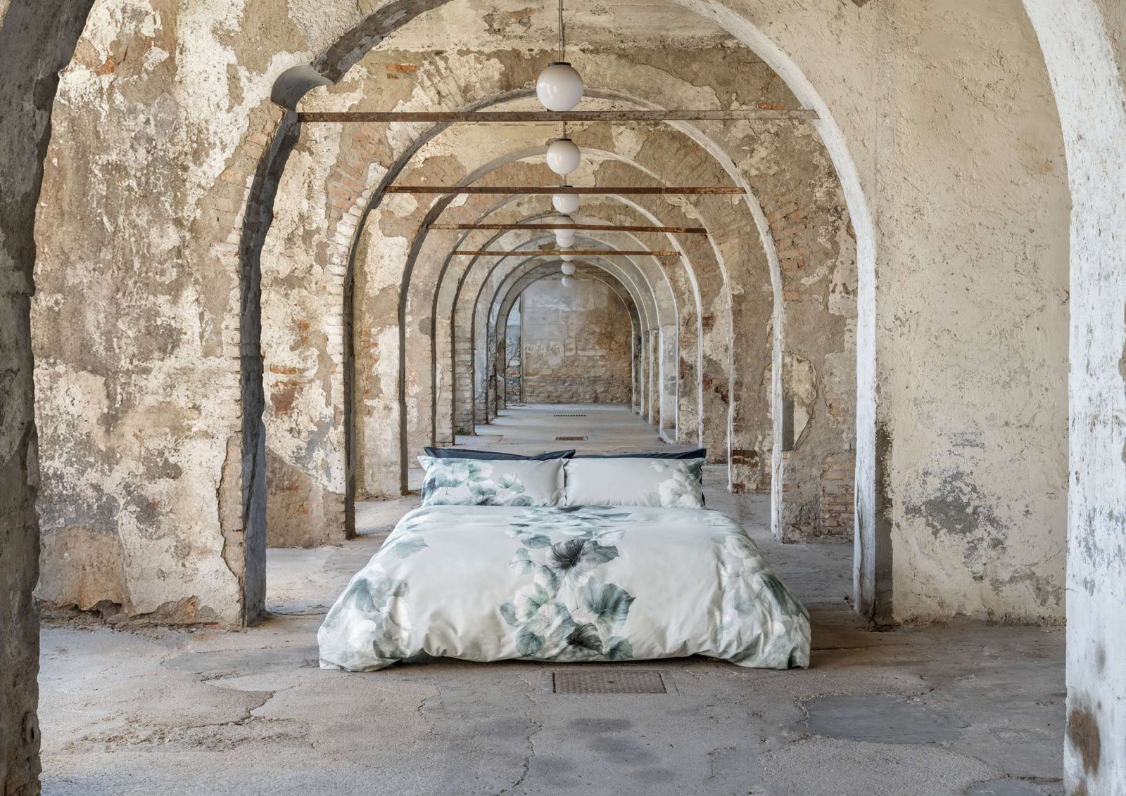 Un letto Galizzi sotto le arcate di un vecchio opificio