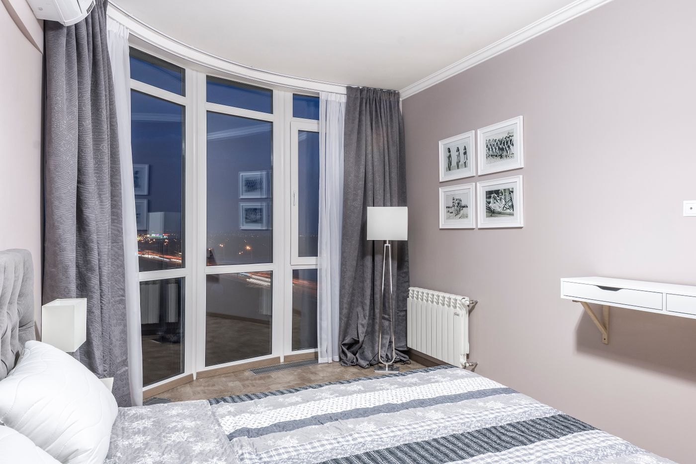 Tende che seguono una vetrata curva in camera da letto